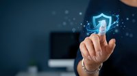 Businessman touching glowing shield icon with checkmark, representing cybersecurity, data protection, and secure digital technology solutions for business.