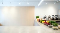 Modern minimalist kitchen interior with white countertop, fresh vegetables, cooking utensils and appliances for culinary preparation and healthy meal planning.
