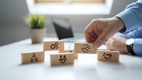 Businessman arranging wooden blocks with teamwork and collaboration icons on office desk representing corporate strategy and human resources management.