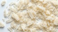 Crushed mineral salt crystals scattered on white background, suitable for cosmetics, spa products, food packaging, and wellness design projects.