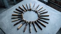 Traditional woodworking hand tools arranged in circular pattern on concrete surface. Vintage chisels and carving instruments for carpentry craftsmanship projects.