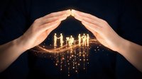 Hands forming protective roof shape over glowing golden house silhouette with falling light particles on dark background, symbolizing home security and insurance.