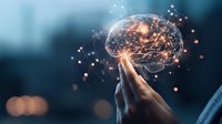 Glowing digital brain hologram floating above hand with neural network connections on dark blue background, representing artificial intelligence and mind technology.
