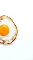 Crispy fried egg with golden yolk isolated on white background for breakfast menu design and culinary projects.