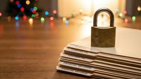 Padlock securing stack of documents on wooden desk with festive bokeh lights creating warm atmosphere for data protection and privacy concepts.