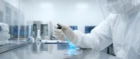 Scientist in protective suit conducting laboratory research with glowing blue sample in modern sterile facility for medical and scientific applications.