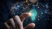 Hand reaching toward glowing lightbulb icon with sparkling particles on dark background representing innovation and creative ideas for business.