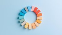Colorful paper segments arranged in circular gradient pattern from blue to coral on light blue background, minimal geometric composition for design projects.