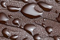 Water droplets on brown surface creating abstract pattern with moisture beads and condensation for natural texture backgrounds and macro photography projects.