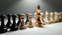 Golden chess king piece standing prominently between opposing black and white pawns on board, symbolizing leadership, strategy and business competition.