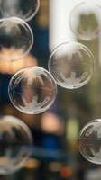 Transparent soap bubbles floating in air with soft bokeh background creating dreamy atmosphere for relaxation and mindfulness concepts.