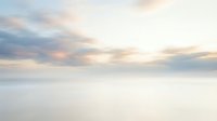 Serene ocean horizon with soft pastel clouds at sunset creating peaceful seascape with calm waters and dreamy sky for meditation and wellness content.