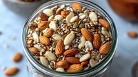 Mixed nuts and seeds blend with almonds, walnuts and pumpkin seeds in glass jar for healthy snacking, cooking and baking recipes.