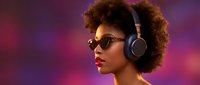 Young African American woman with curly afro hair wearing sunglasses and headphones against vibrant purple pink gradient background for music entertainment.