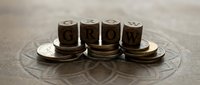 Wooden letter blocks spelling GROW arranged on circular platform with compass design, symbolizing business development and personal growth journey.
