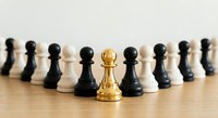 Golden chess king piece standing out among black and white pawns on wooden surface, symbolizing leadership, strategy, and business success concepts.