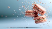 Pink macarons with crumbs floating in air against blue background, dynamic food levitation composition showing sweet dessert in motion.