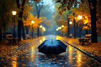 Black umbrella on wet autumn park alley with glowing lanterns, fallen yellow leaves and empty benches during rainy evening, moody atmospheric scene.