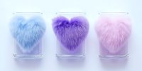 Fluffy heart-shaped decorative elements in pastel blue, purple, and pink colors arranged in glass containers on light background, creating soft romantic atmosphere.