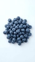 Fresh blueberries arranged in a circular cluster on white background, showcasing ripe berries with natural bloom coating for food and nutrition content.