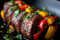 Juicy grilled beef kebab with colorful bell peppers and fresh herbs, seasoned with black pepper and sesame seeds on dark background, macro food photography.