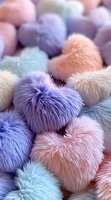 Soft fluffy heart-shaped decorative pillows in pastel colors - purple, pink, and blue. Plush furry texture creates romantic Valentine's day or nursery decor background.