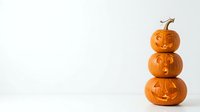 Stacked carved pumpkins with jack-o-lantern faces isolated on white background, perfect for seasonal marketing, Halloween designs, greeting cards, and festive promotional materials.
