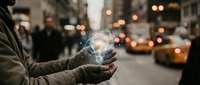 Person holding glowing digital globe with network connections on busy city street at dusk with blurred traffic lights and urban bokeh background.