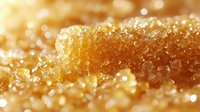 Golden honeycomb dripping with fresh honey, sparkling water droplets creating luxurious texture for food photography and natural sweetness concepts.