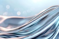 Luxurious flowing silk fabric in pastel blue and rose gold tones with glitter effect creates elegant waves and soft folds against blurred bokeh background.