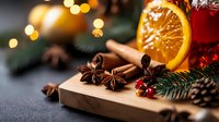 Aromatic spices, orange slice and mulled wine on wooden board with festive bokeh lights and pine branches, cozy winter holiday atmosphere.