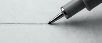 Marker pen with black tip drawing a straight line on white paper surface, suitable for design, art, and creative projects.