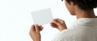 Man holding blank white card in hands, rear view isolated on white background for mockup and design purposes.