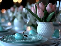 Elegant Easter table setting with pink tulips in white ceramic vase, turquoise egg decoration and bokeh lights creating festive spring atmosphere.