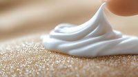 White cosmetic cream swirl on golden glittery surface for luxury skincare and beauty product advertising campaigns.
