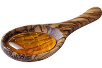 Honey dripping in wooden olive wood spoon with natural grain pattern texture, isolated on white background for culinary and food photography.
