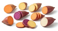 Fresh sweet potato varieties with colorful flesh slices showing orange, purple and yellow interiors isolated on white background for healthy cooking designs.