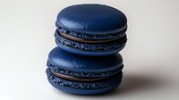 Two elegant navy blue macarons stacked on white background, perfect for bakery menus, dessert photography, and culinary design projects.