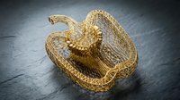 Golden snake sculpture coiled on dark slate surface, metallic reptile art object for luxury home decor and interior design styling.
