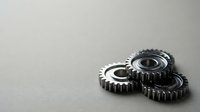 Metal mechanical gears on neutral background for industrial engineering and machinery concepts in manufacturing and technology applications.