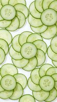 Fresh cucumber slices arranged in circular patterns on white background. Healthy vegetable ingredient for salads, skincare and spa treatments.