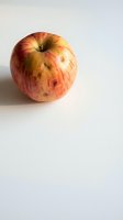 Single red yellow apple with natural blemishes on white background for healthy eating organic food concepts and nutrition lifestyle designs.