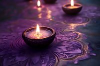 Glowing candles in decorative bowls on purple ornate fabric create serene atmosphere for meditation, spa, or spiritual practices.
