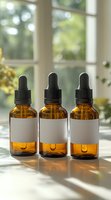 Amber glass dropper bottles with blank labels on windowsill in natural sunlight. Aromatherapy, essential oil, or medicine containers casting soft shadows.