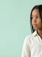 Young African woman with braided hair wearing cream linen shirt against mint green background, looking away thoughtfully. Suitable for corporate, lifestyle, and editorial design projects.