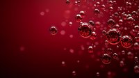 Red liquid with floating bubbles creating abstract pattern for beverage advertising and cosmetic product backgrounds.