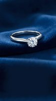 Elegant diamond solitaire engagement ring on luxurious blue velvet surface for wedding proposals and romantic celebrations.
