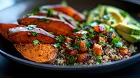 Grilled sweet potato with quinoa salad, fresh herbs and avocado slices in bowl. Healthy vegetarian meal with roasted vegetables and nutritious grains for lunch.