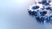 Metallic gear wheels with blue tint on reflective surface, shallow depth of field creates soft background blur, highlighting industrial engineering concept.