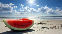 Fresh watermelon slice on sandy beach with bright sun, ocean waves and white fluffy clouds in blue sky, summer vacation concept for healthy lifestyle.